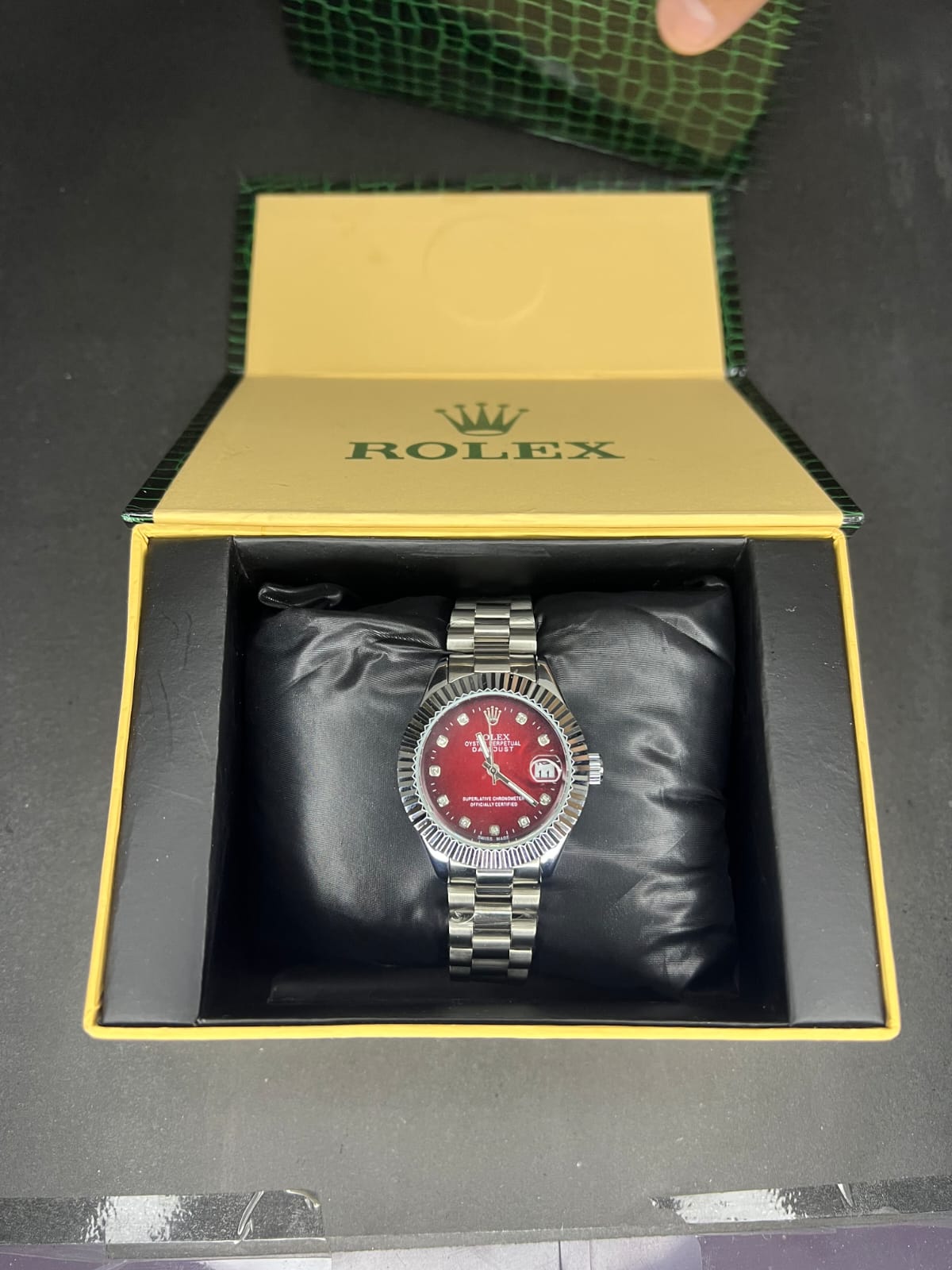 Rolex Oyster Perpetual Cosmograph Daytona with a black dial, gold casing, and a black strap.