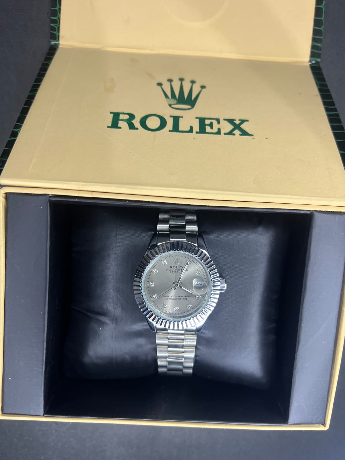 Rolex Oyster Perpetual Cosmograph Daytona with a black dial, gold casing, and a black strap. 