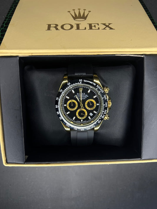 Rolex Oyster Perpetual Cosmograph Daytona with a black dial, gold casing, and a black strap. 